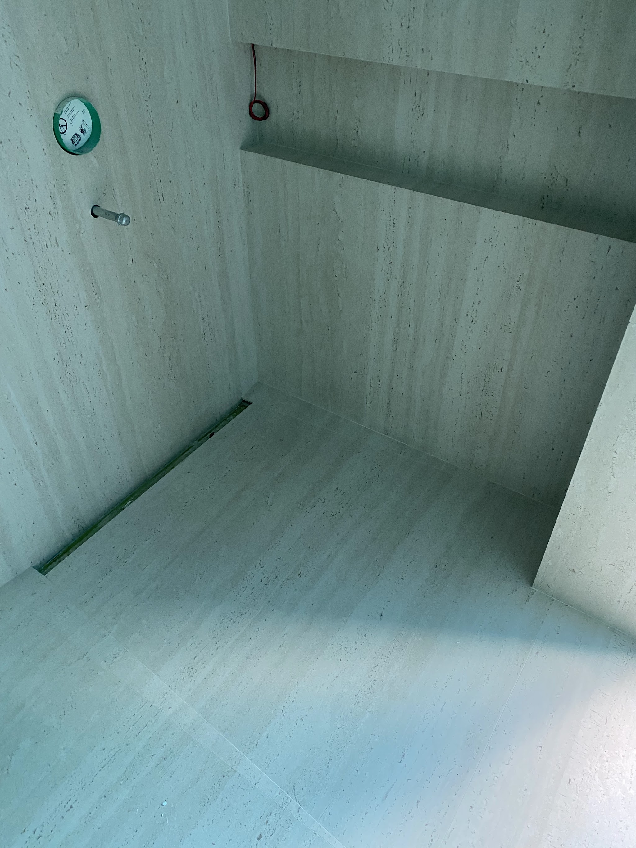 Pale travertine-look large-format tile shower and floor